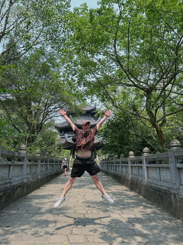 A guest jumping for joy on the path to Bai Dinh pagoda