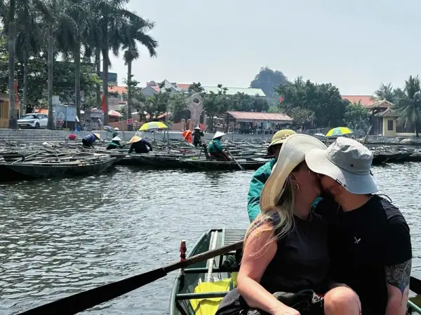 A couple in a rowing boat among the karst peaks