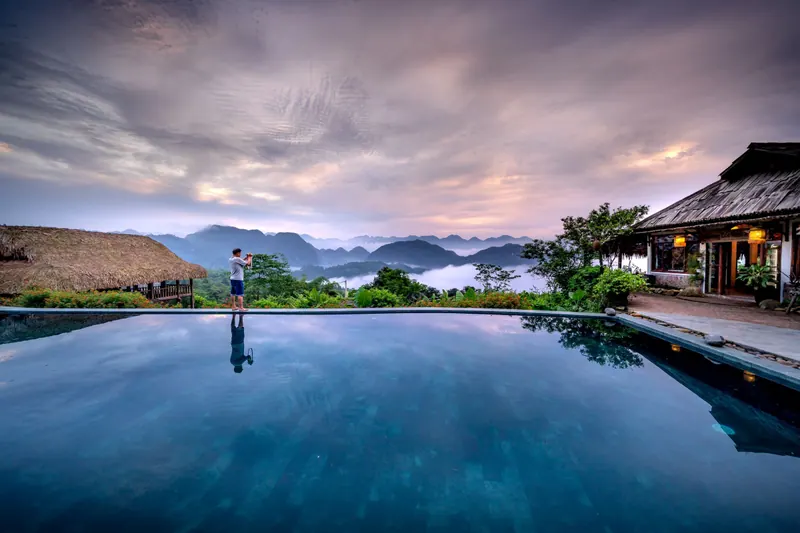 A pool and terrace looking over rice fields and mountains